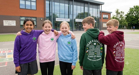 Year 6 pupils wearing personalised Year 6 leavers hoodies outside their primary school.