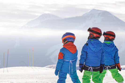 School students wearing ski clothing on a snowy mountain, representing ski trip hoodies for school groups.