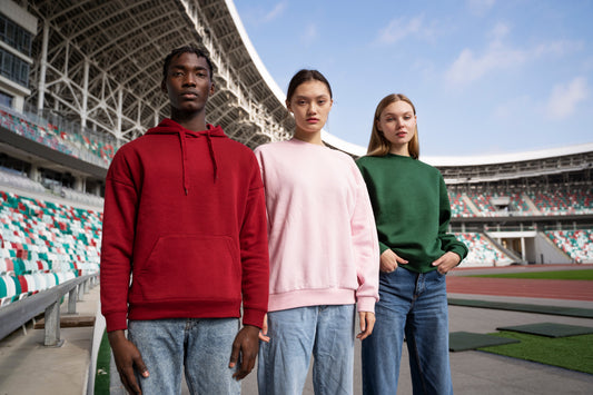 Young athletes wearing custom hoodies for sports teams in a stadium, showcasing durable personalised sports club apparel.